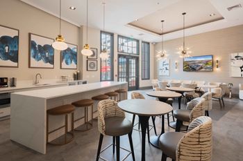 A modern clubhouse with kitchen with a bar area and dining area at harbor pointe apartments, new jersey, 07002